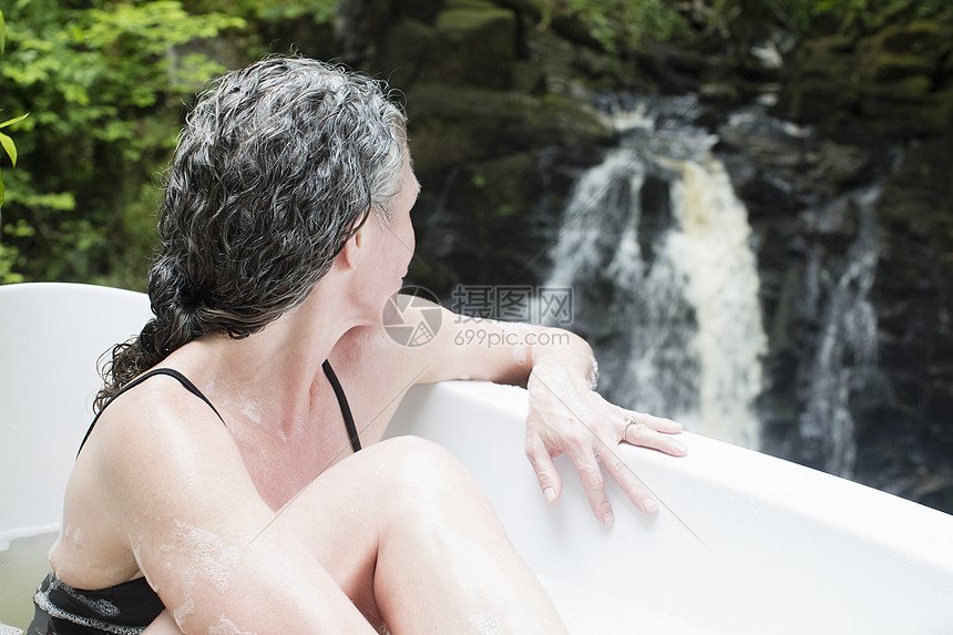 在瀑布前泡浴成年女性图片