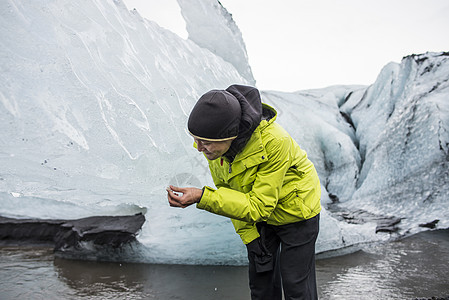 在冰岛索尔海马乔库观看冰块的男游客图片