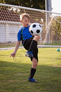 男孩在球场上踢足球图片