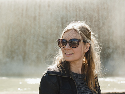 西班牙巴塞罗那喷泉前戴墨镜的成年女子肖像图片