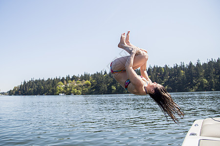 从游艇跳入湖中的的年轻女性图片