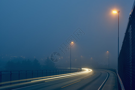 挪威罗加兰县Haugesund市路灯照亮的迷雾道路灯光线条的淡化观点背景图片