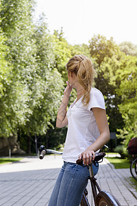 有马尾辫的年轻女子仰着自行车向外看图片