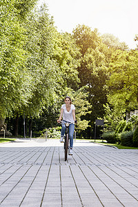 年轻女骑自行车前视线图片