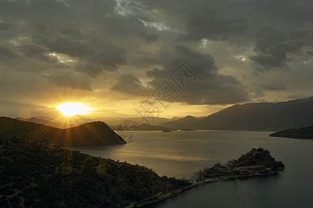 云南日出时太阳光山和卢古湖图片