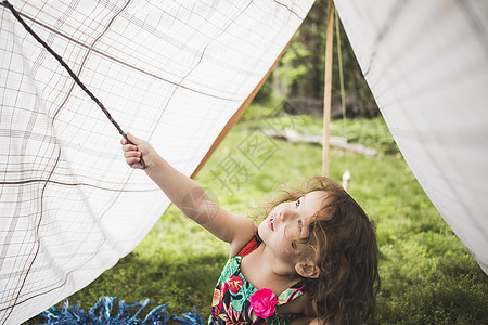 女孩用树枝撑起帐篷图片