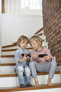 两个男孩坐在楼梯上看手机图片