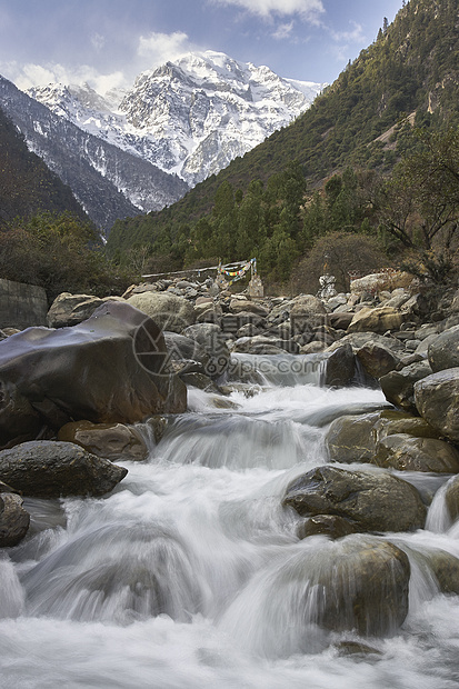 云南香格里拉县雪山下河水流图片