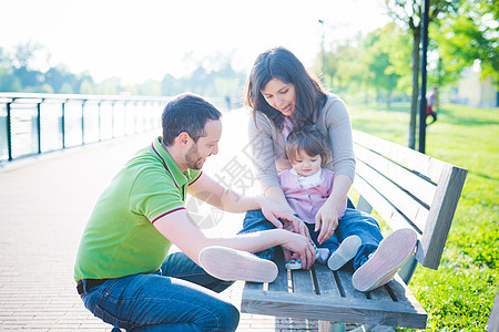 成年夫妇与女儿在公园长椅上图片