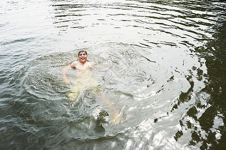 男孩在湖中游泳图片