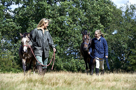 母亲和女儿在田间骑马图片