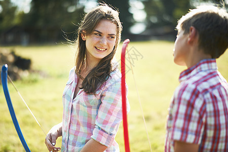 少女在练习射箭时和兄弟说话图片