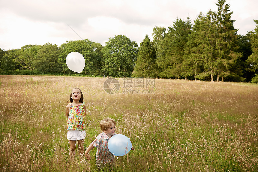 高草地的兄妹玩气球图片