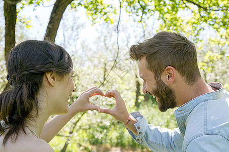 年轻夫妇用手比心图片