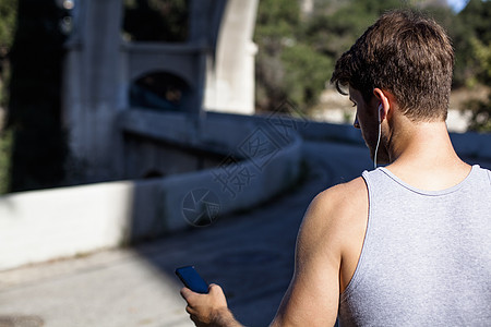 慢跑的男人在智能手机上选择音乐图片
