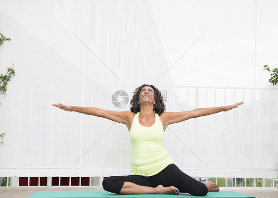 在瑜伽垫上锻炼的女性图片