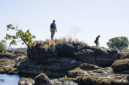 赞比亚维多利瀑布旁跨越河流的夫妇图片