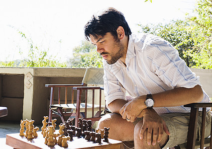 在赞比亚公园的小屋下象棋的中年成人男子图片