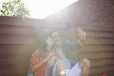 成人中年夫妇在屋顶派对上使用手机自拍图片