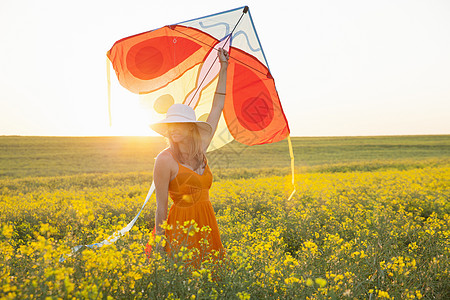 手持风筝的卡诺拉田臂中成年妇女图片