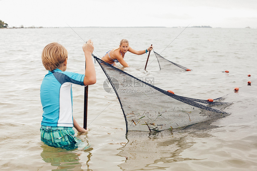 使用传统渔网捕鱼的少年们图片