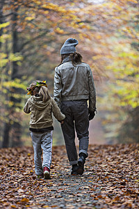 母亲和女儿在秋林中行走图片