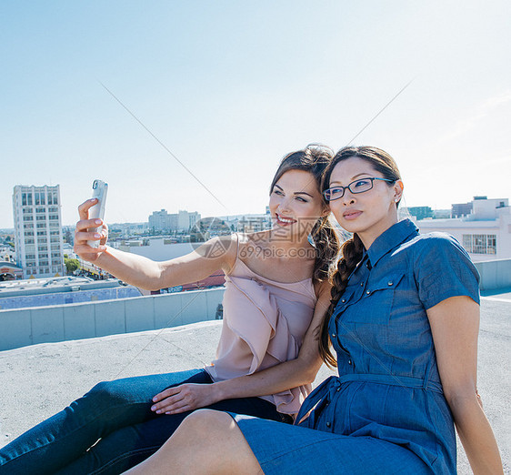 美国加利福尼亚州洛杉矶市女商人在屋顶露台上用智能手机自拍图片