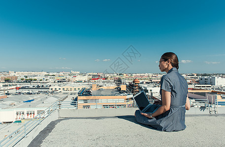 美国加利福尼亚州洛杉矶屋顶露台使用笔记本电脑的女商人图片