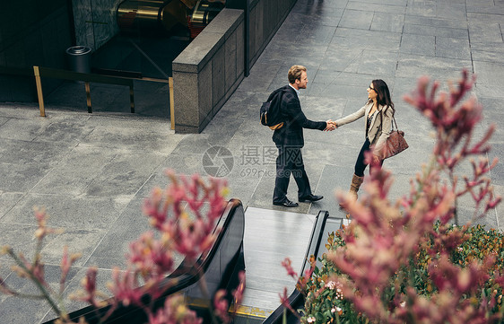 城市商人和女士握手的俯视视角图片