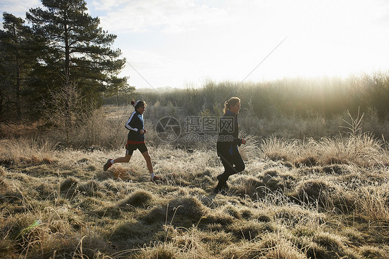 母亲和儿子在寒冷的草原上奔跑图片