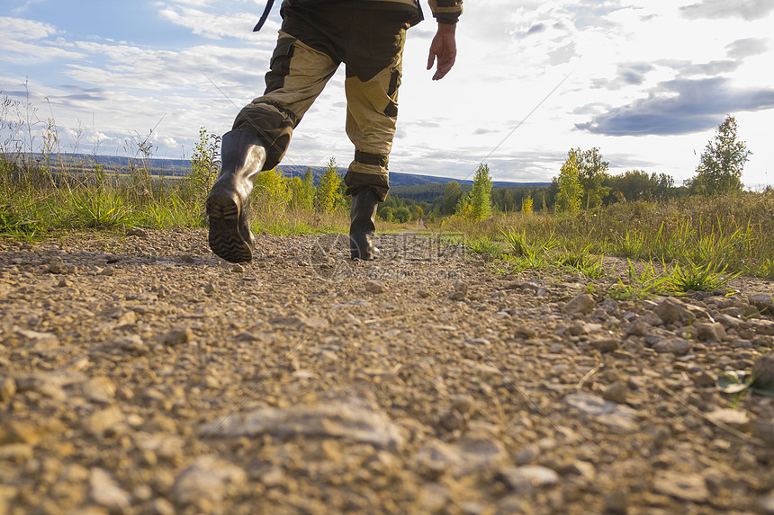成年中男子在泥土路上行走