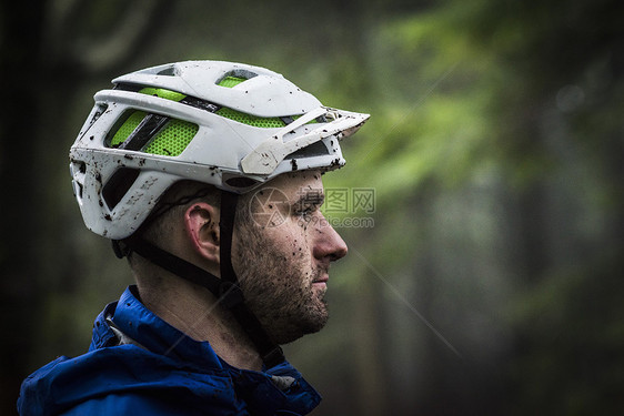 满脸泥土骑脚踏车的男性特写图片