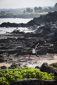 在沙滩上练瑜伽的年轻女性图片