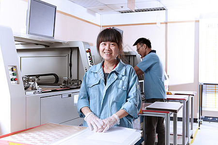 在电子设备厂的年轻女性看着镜头微笑图片