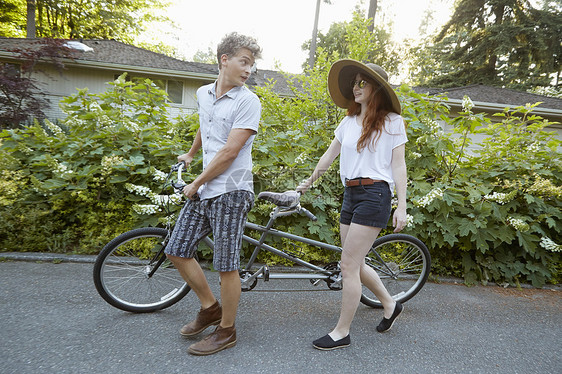 在郊区路上的年轻夫妇准备搭乘双轮车图片