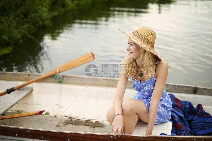在河上划船长着金发的年轻女子肖像图片