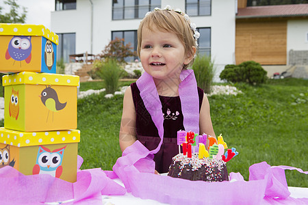 花园里有生日蛋糕和粉红丝带的女幼儿肖像图片