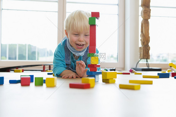 在客厅地板上玩砖头的男幼儿图片