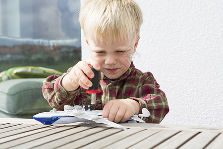 男孩在庭院桌上准备玩具飞机图片