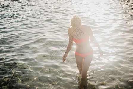 中年成妇女穿着比基尼在日光海中漂浮的比基尼图片