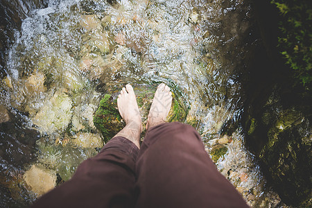 悬浮在溪流中岩石上的双腿视线图片