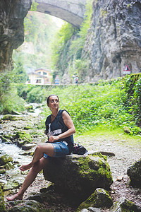 坐在溪流岩山和石桥的上妇女背景意大利加尔达图片