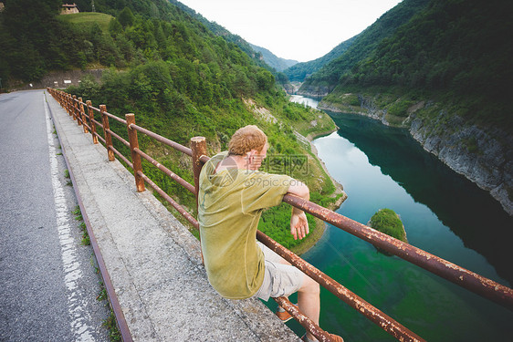 意大利加尔达湖坐在路边栏杆上的人图片