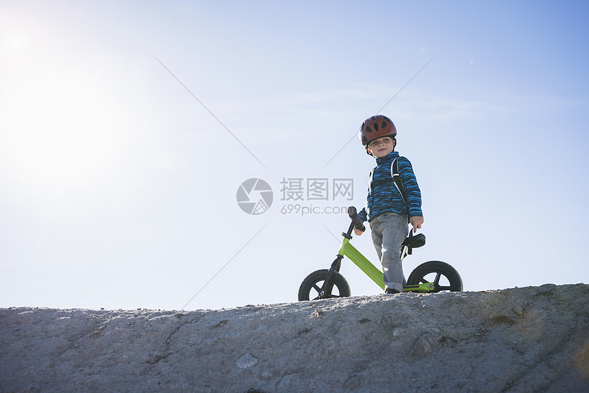 山坡上骑平衡自行车的男孩图片
