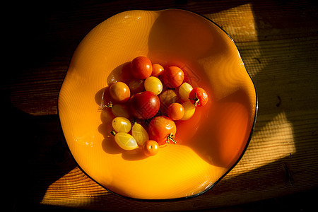 木桌上橙色碗中西红柿的覆盖视图图片