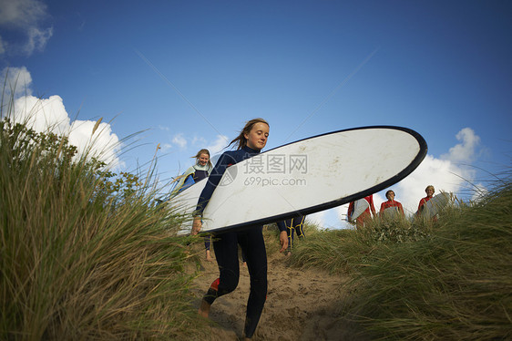 拿着冲浪板走向海洋的冲浪者图片