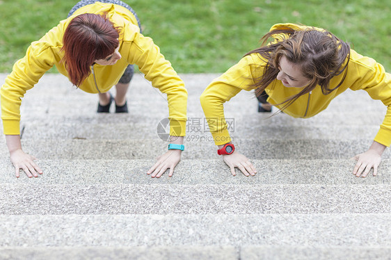 在台阶上做俯卧撑的年轻女性图片