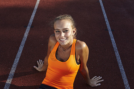 坐在赛道上的年轻女选手肖像图片