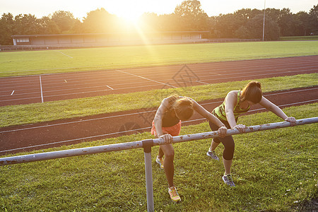 两名年轻妇女在体育场上锻炼图片