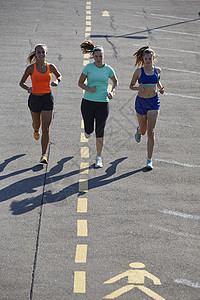 三名年轻女跑在停车场图片